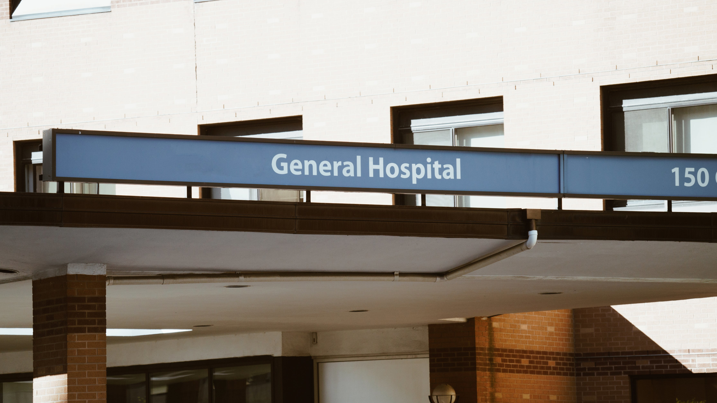 Blue sign with 'General Hospital' text on a building exterior